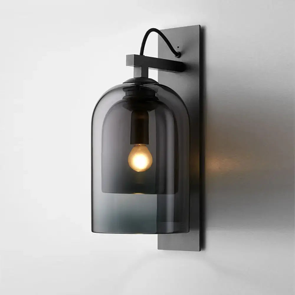 Mid-century black wall sconce with dark gray smoked dome glass shade and black metal bracket for living room use