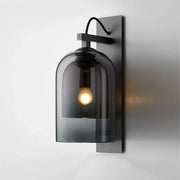 Mid-century black wall sconce with dark gray smoked dome glass shade and black metal bracket for living room use