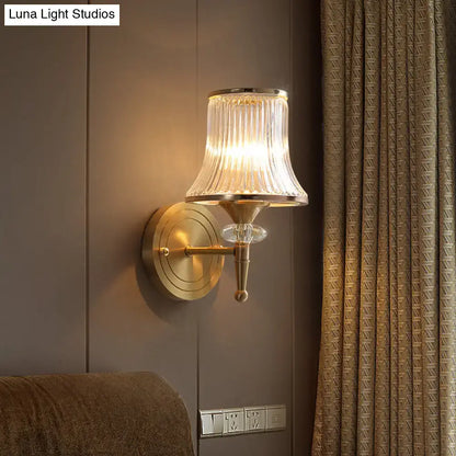 Gold-toned mid-century brass crystal ribbed wall mounted lamp with fluted glass shade for living room use