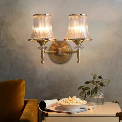 Mid-century brass wall mounted lamp with two crystal ribbed glass shades and decorative crystal accents for living room