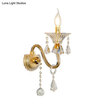 Elegant mid-century brass wall mounted sconce with crystal shade and gold-toned teardrop crystal accents for bedroom lighting