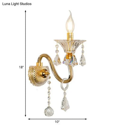 Gold-toned mid-century brass crystal shade wall mounted sconce with faceted crystals and teardrop pendants for bedroom lighting