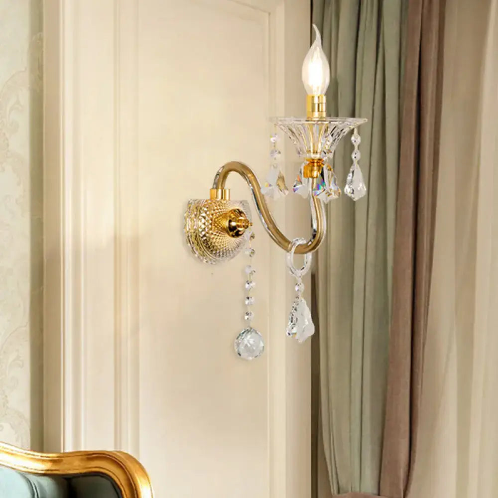 Mid-century brass crystal shade wall mounted sconce with gold-toned curved arm and clear faceted crystals for bedroom lighting