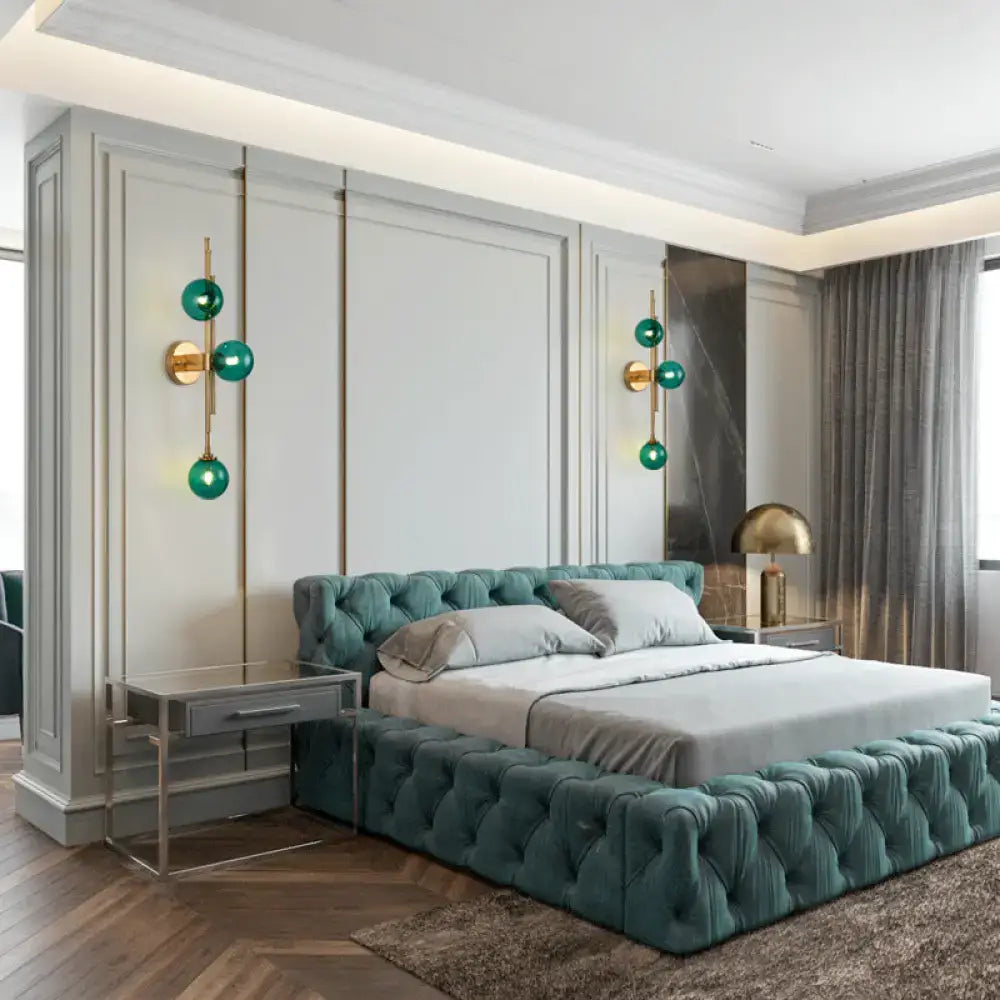Teal tufted velvet platform bed with matching headboard and footboard displayed with mid century brass finish clear glass orb sconce