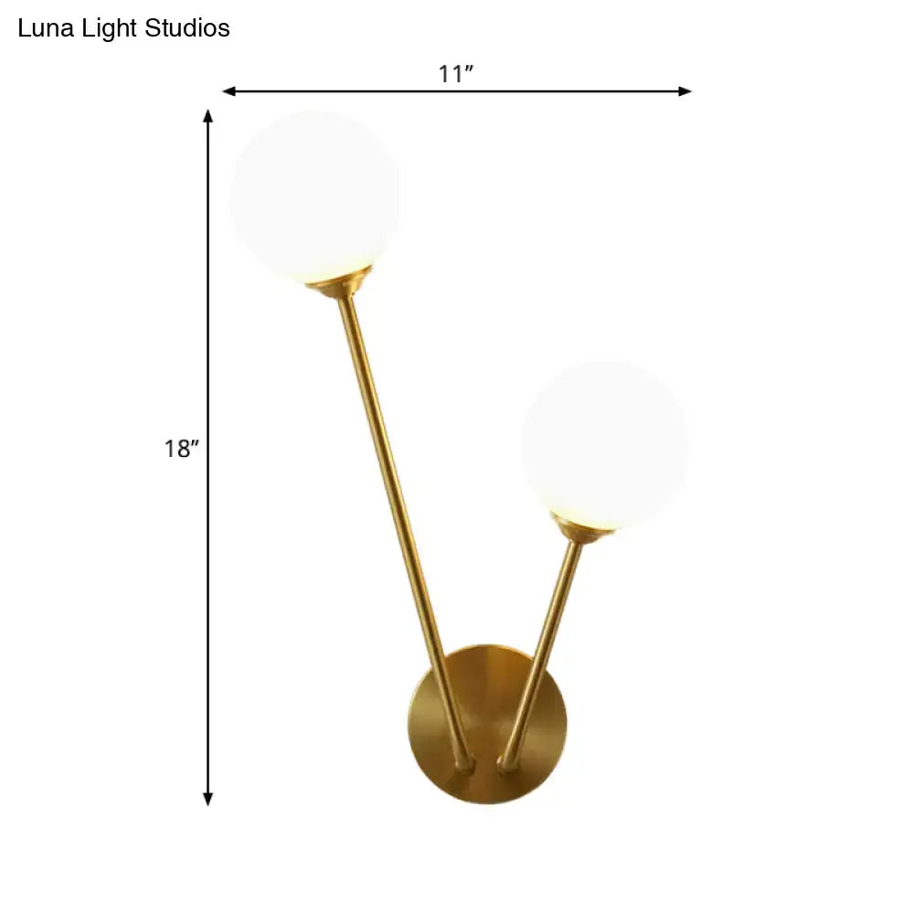 Gold-toned mid century wall light with two opaline glass spherical shades and bulb base for living room use