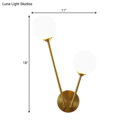 Gold-toned mid century wall light with two opaline glass spherical shades and bulb base for living room use