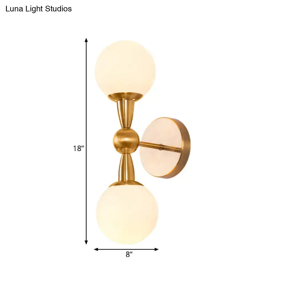 Gold-toned mid century wall mount light with two frosted opal glass globes suitable for 220v-240v and 110v-120v use
