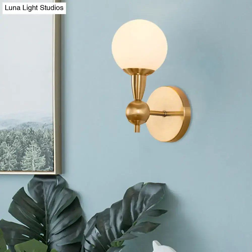Mid century wall mount light with gold-toned metal arm and frosted opal glass globe for 220v-240v 110v-120v use