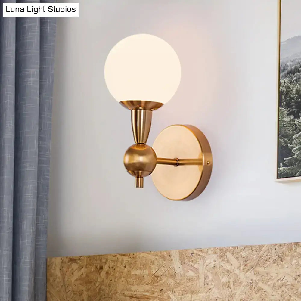 A sleek mid century wall mount light in brass with a frosted opal glass globe for bedroom 220v-240v 110v-120v use