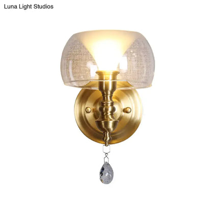 Mid century brass-finished wall sconce with a flared textured glass shade and a crystal droplet pendant for bedroom