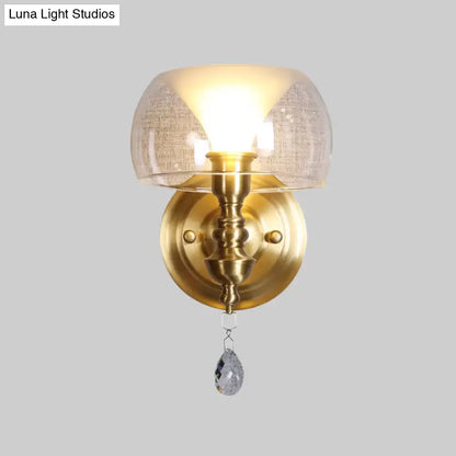 Antique brass mid century wall sconce with textured flared glass dome and dangling crystal droplet for bedroom