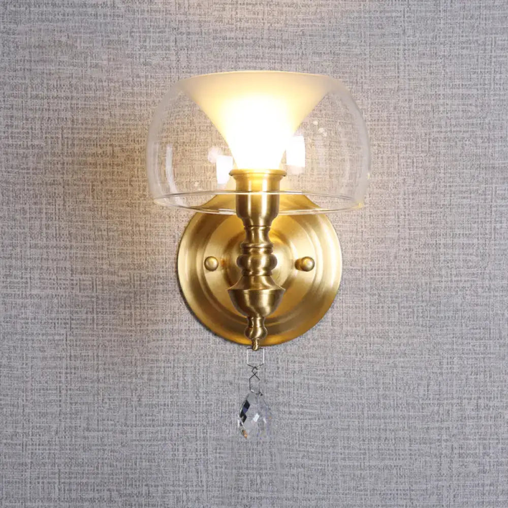 Mid century gold wall sconce with clear glass flared shade and crystal droplet for bedroom lighting