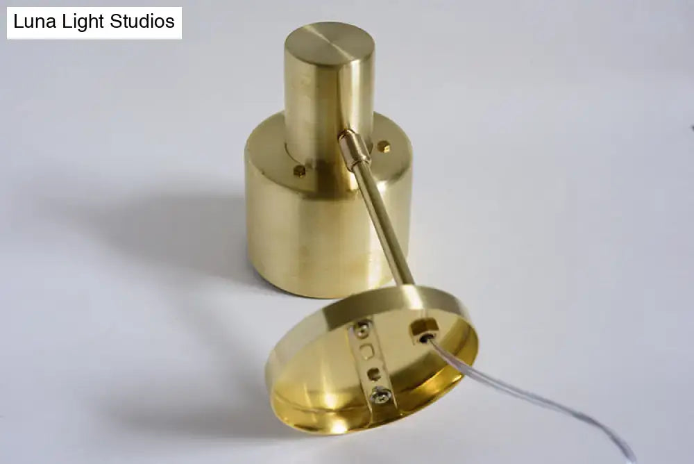 Brass-finished cylindrical pendant light with visible mounting hardware for mid-century gold metal cage home wall lighting