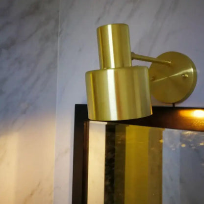Gold-toned brass mid-century wall lighting with cylindrical stacked design and circular mounting plate for home wall lighting