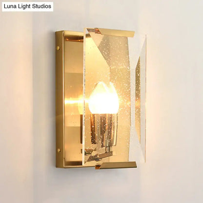 Mid century gold wall sconce with frosted speckled glass panels and bulb base for elegant living room lighting