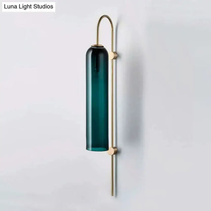 A mid century gooseneck wall light with a deep teal glass shade and slender brass frame for bedroom use