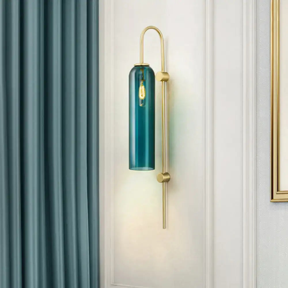 Teal cylindrical glass mid century gooseneck wall light with brass finish and exposed filament bulb for bedroom use