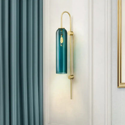 Teal cylindrical glass mid century gooseneck wall light with brass finish and exposed filament bulb for bedroom use