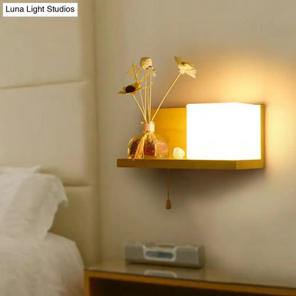 Warm-toned rectangular milk glass cube wall light with minimalist wooden frame and soft glowing light for bedroom sconce