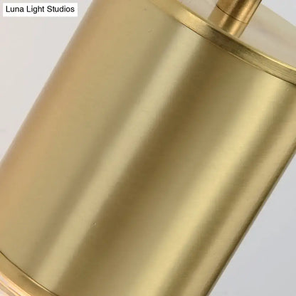 Minimal brass and glass wall sconce light with brass-finished cylindrical base featuring smooth polished surface and banding