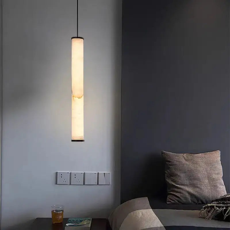 Minimalist amber marble and black pendant light with a warm glow and polished copper accents for kitchen dining lighting area