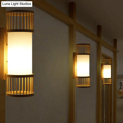 Minimalist warm-toned wall lamp with bamboo slat accents and frosted glass diffuser in a cylinder shade wall sconce design