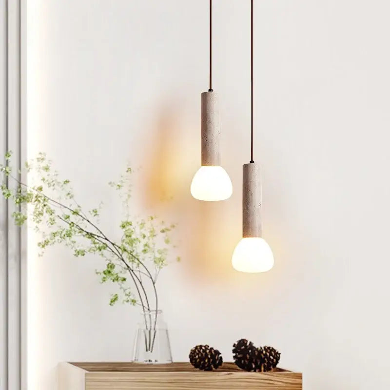 Two minimalist beige concrete pendant lights with warm glass stone led shades for kitchen decorbites glass stone lighting