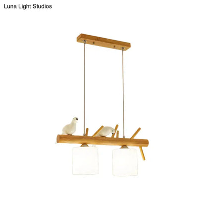 Beige drum island lighting featuring a minimalist wooden pendant with white ceramic birds and frosted glass shades