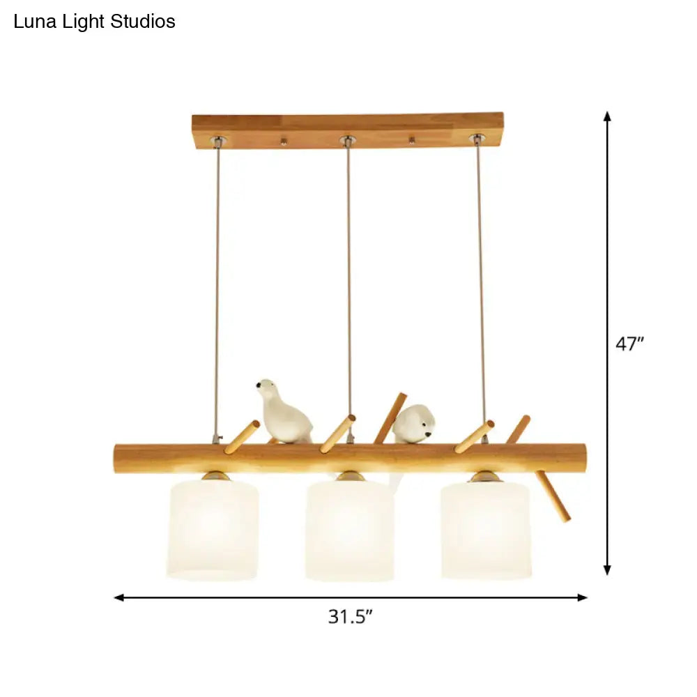 DecorBites beige drum island lighting with three frosted glass shades and ceramic birds on natural wood beam design