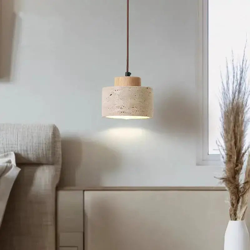 Minimalist pendant light with beige stone shade and natural wood top suspended by brown cord for kitchen dining room