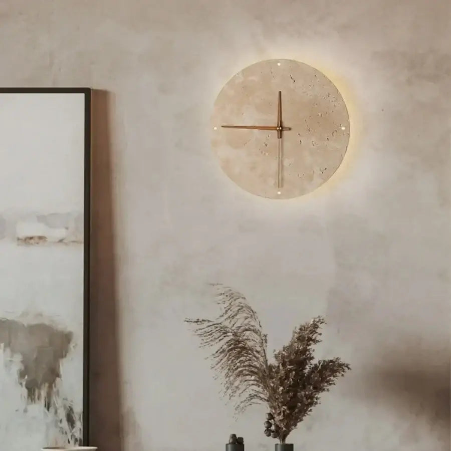 Minimalist beige travertine stone clock with slender brass hands complements led wall lights for bedroom decor