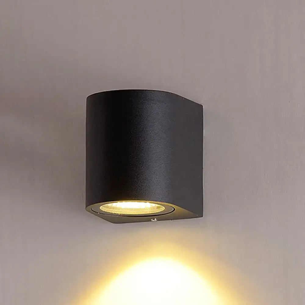 Minimalist black aluminum outdoor cylinder wall light with matte finish and warm focused light for outdoor space direct wired electric