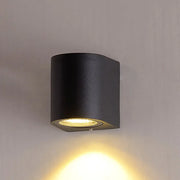 Minimalist black aluminum outdoor cylinder wall light with matte finish and warm focused light for outdoor space direct wired electric