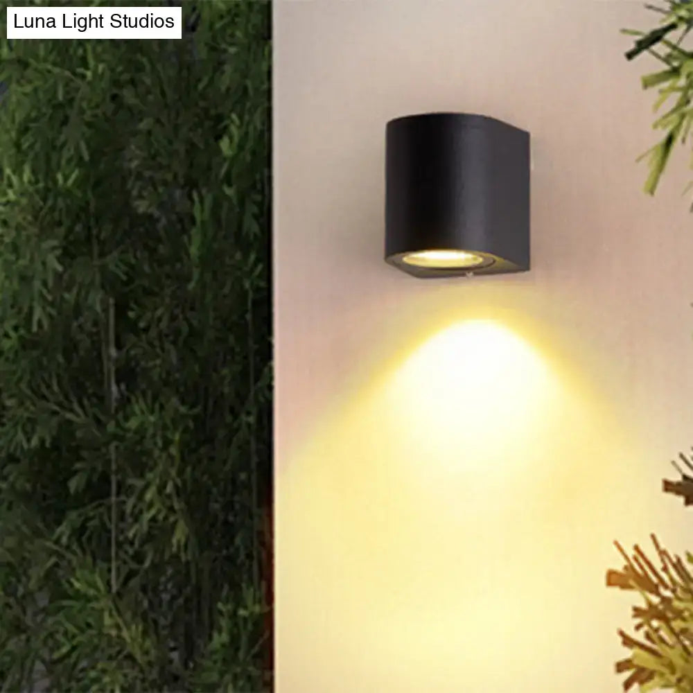 Minimalist black aluminum outdoor cylinder wall light with warm focused beam for direct wired electric outdoor space