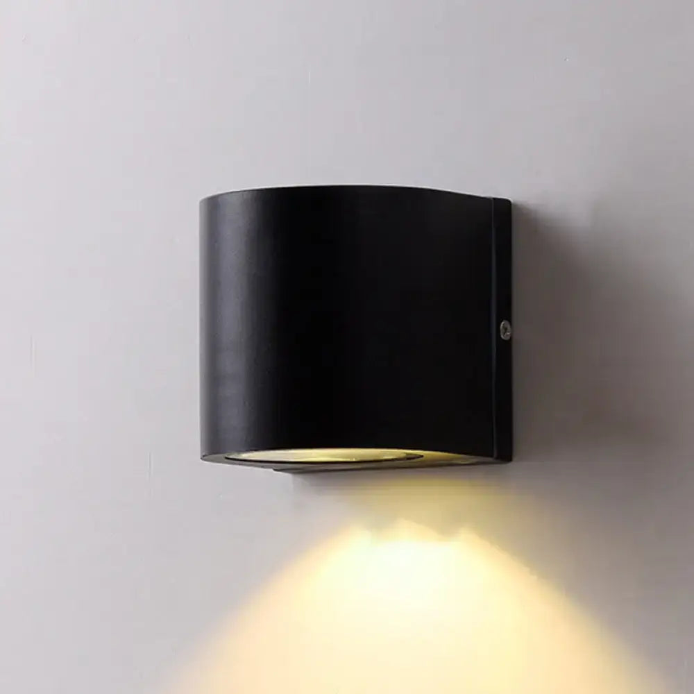 Minimalist black aluminum outdoor cylinder wall light with warm yellow illumination for direct wired electric outdoor space