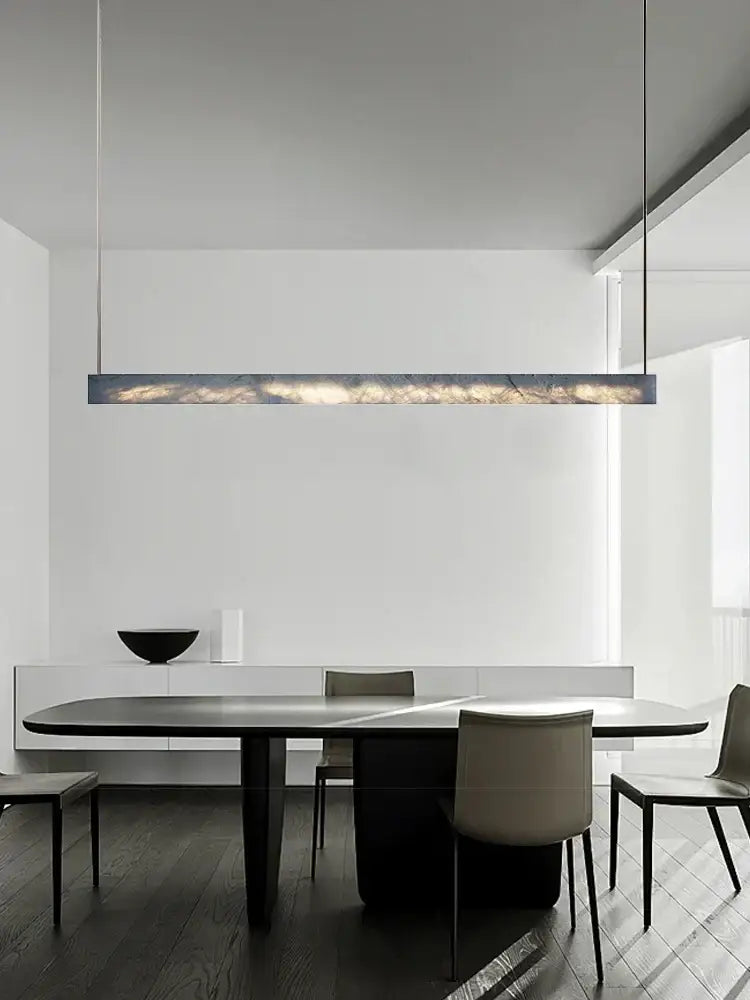 A minimalist black and amber marble design pendant light with a sleek rectangular shape and warm glowing interior for office
