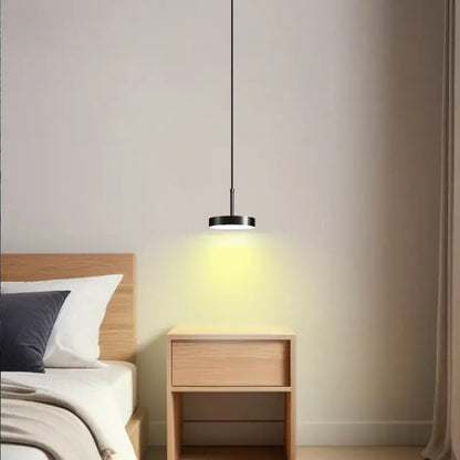 Minimalist black pendant light with frosted white acrylic featuring a sleek circular design and warm diffused glow for dining room