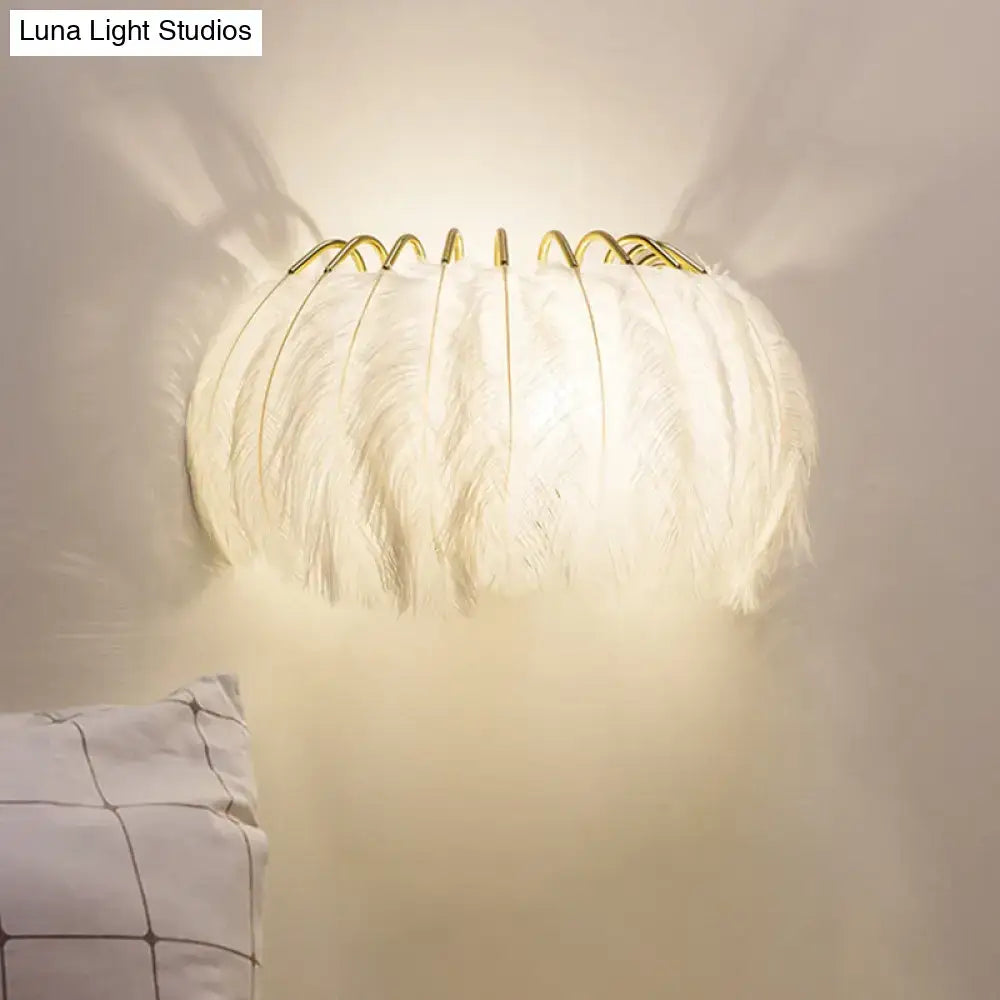 Minimalist black and gold feather wall sconce with white feathers and gold-toned metal frame light type fixture height