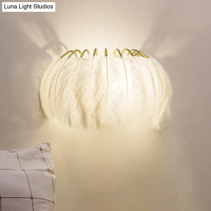 Minimalist black and gold feather wall sconce with white feathers and gold-toned metal frame light type fixture height