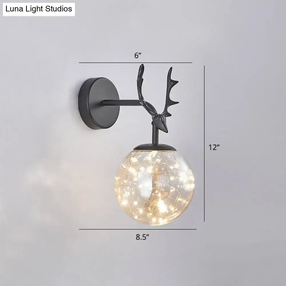Minimalist black metal deer head wall sconce with glass globe filled with warm fairy lights for bedroom decor