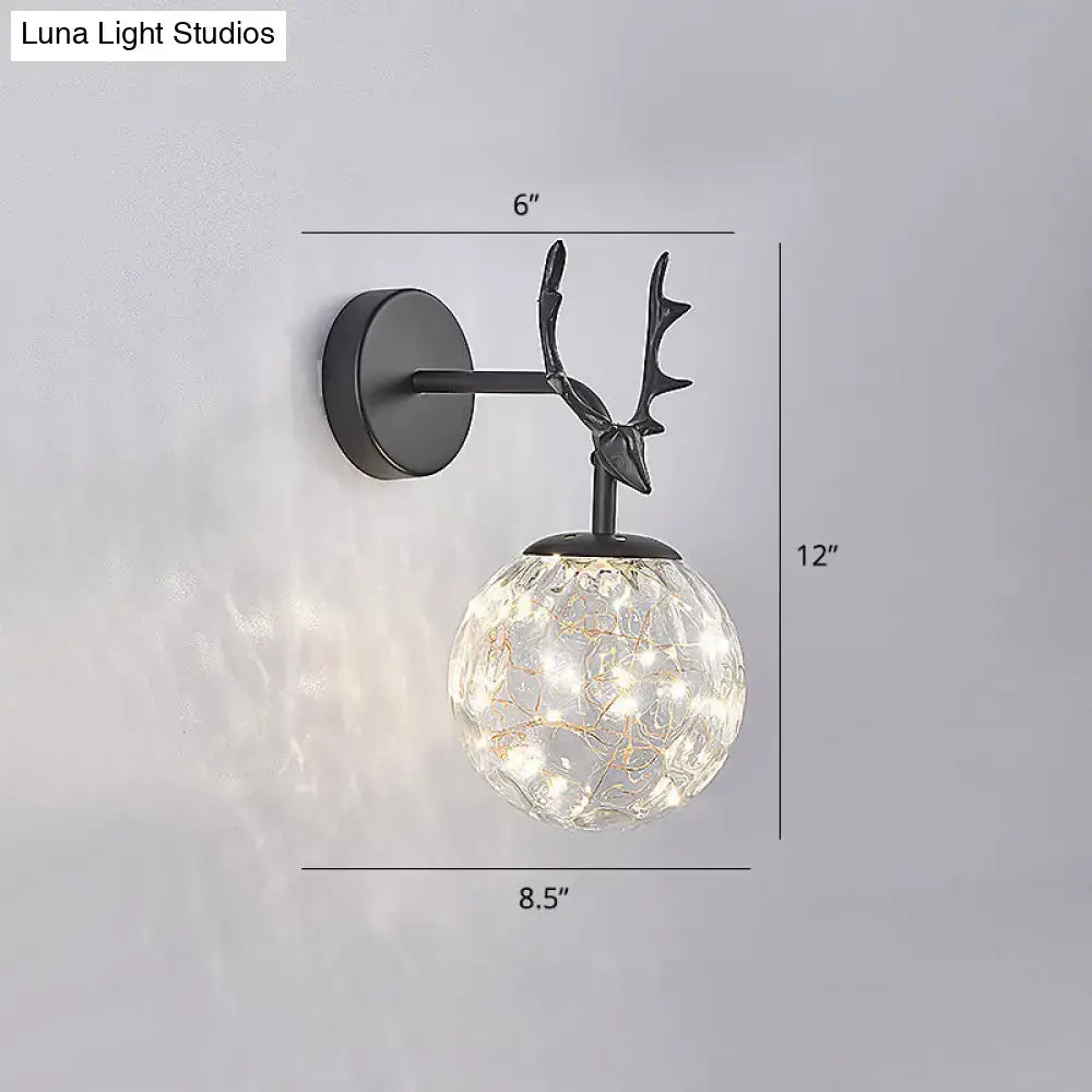 Minimalist black metal deer head wall sconce with textured crackled glass globe and warm LED fairy lights for bedroom
