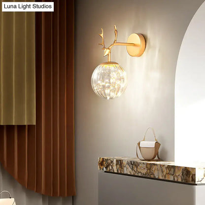 Gold-toned deer antler wall sconce with faceted crystal globe shade minimalist black antler glass globe sconce for bedroom lighting