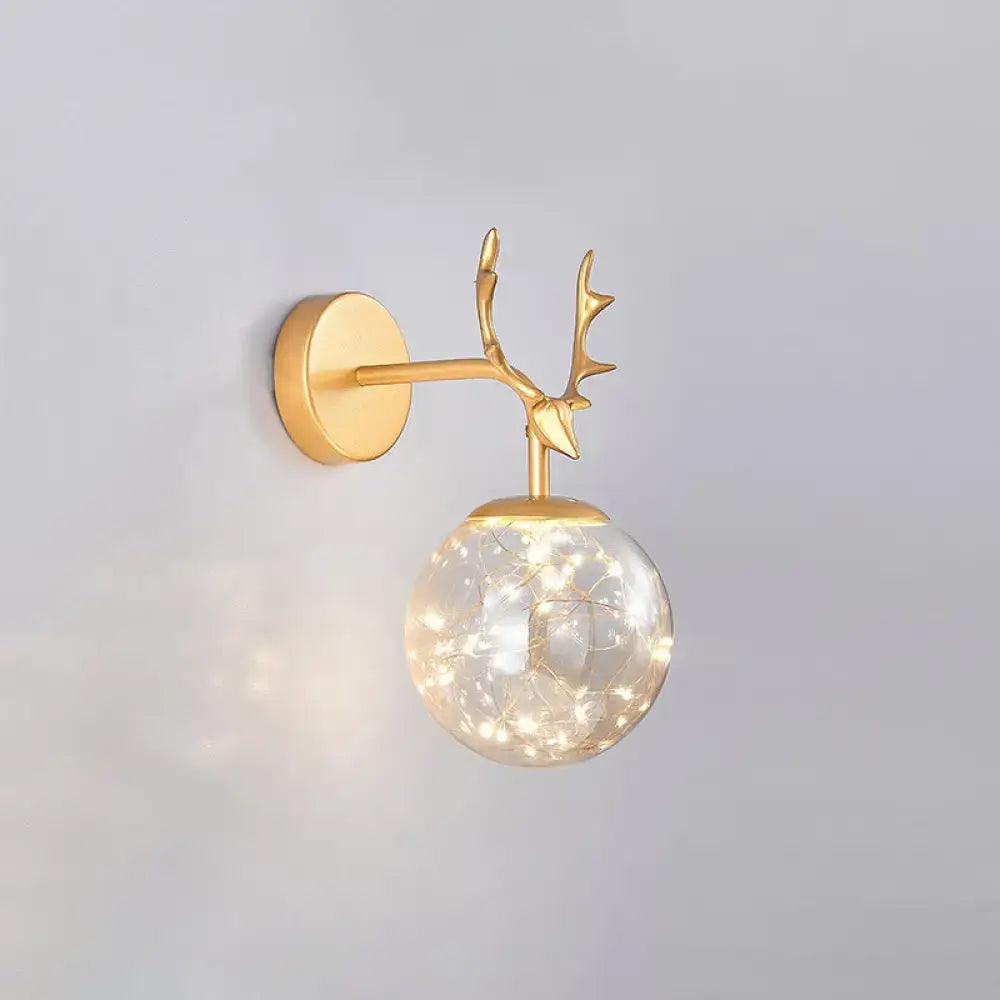 Minimalist black antler wall sconce with glass globe housing warm fairy lights for bedroom lighting