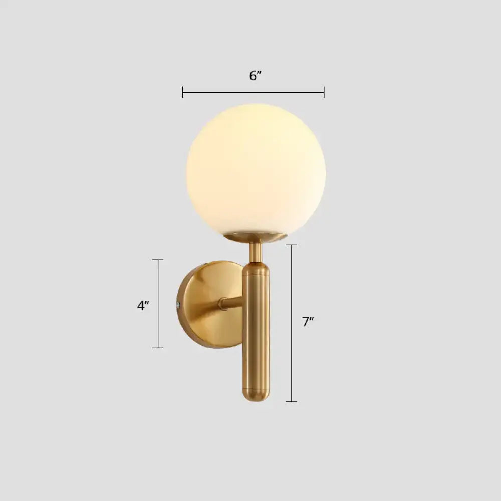 Gold-toned minimalist bedroom wall sconce with white clear brass ball shade and frosted glass globe for corridor use