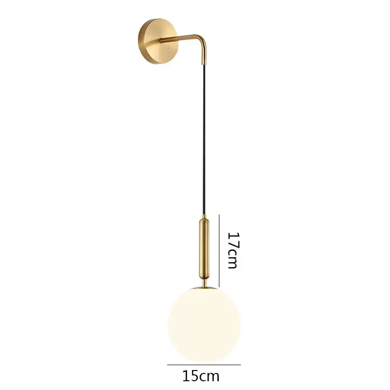 Minimalist black and brass glass ball wall lamp with gold-toned curved arm and frosted globe for bedroom decorbites glass ball