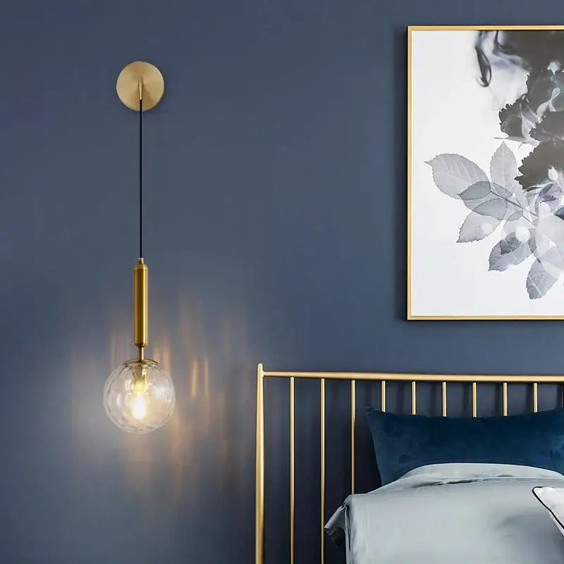 Minimalist gold-toned wall lamp with brass glass ball and clear globe bulb for decorbites glass ball wall lighting