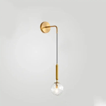 Gold-toned minimalist wall lamp with curved arm, black cord, and faceted crystal globe for decorbites glass ball wall decor