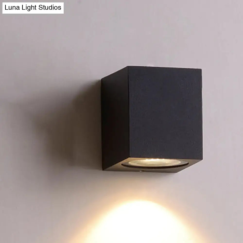 Minimalist black matte wall sconce with brass detail led flush mount emitting warm light for corridor lighting