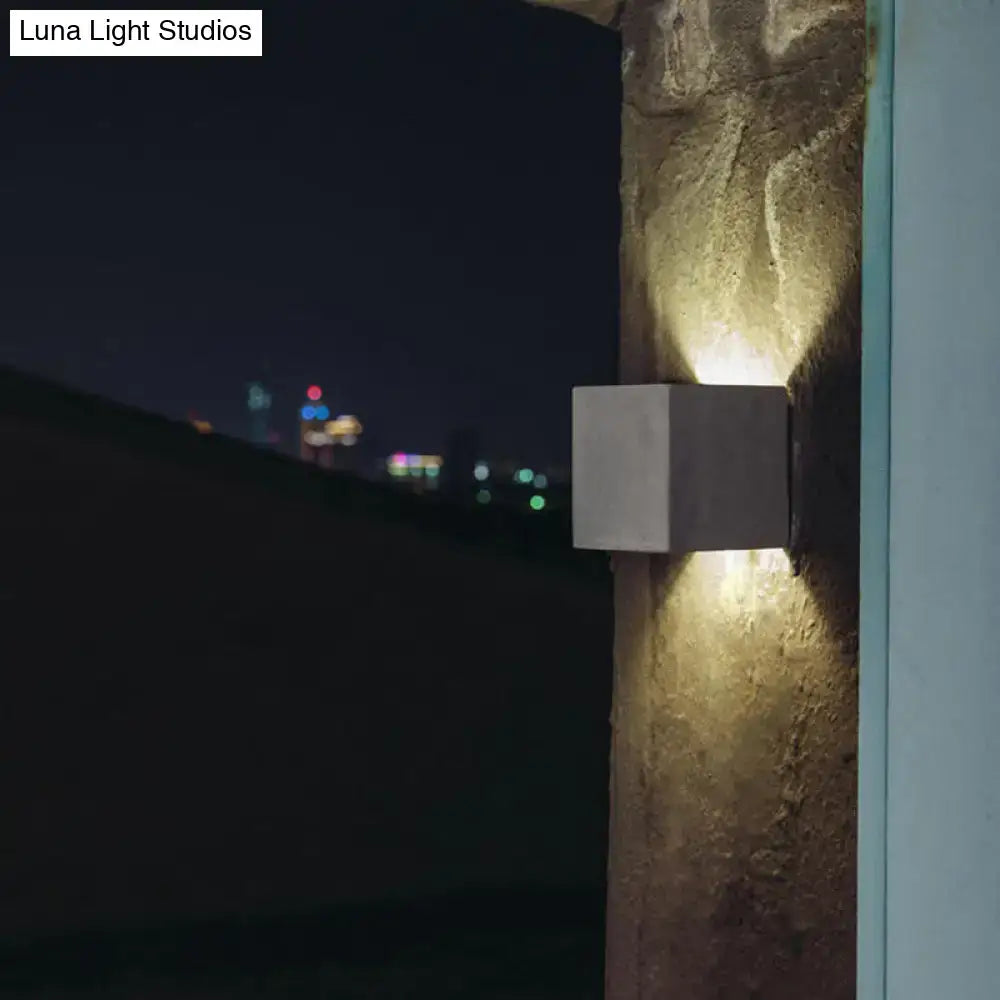 Minimalist black cement led wall lamp with modern concrete cube design emitting warm focused glow for living room