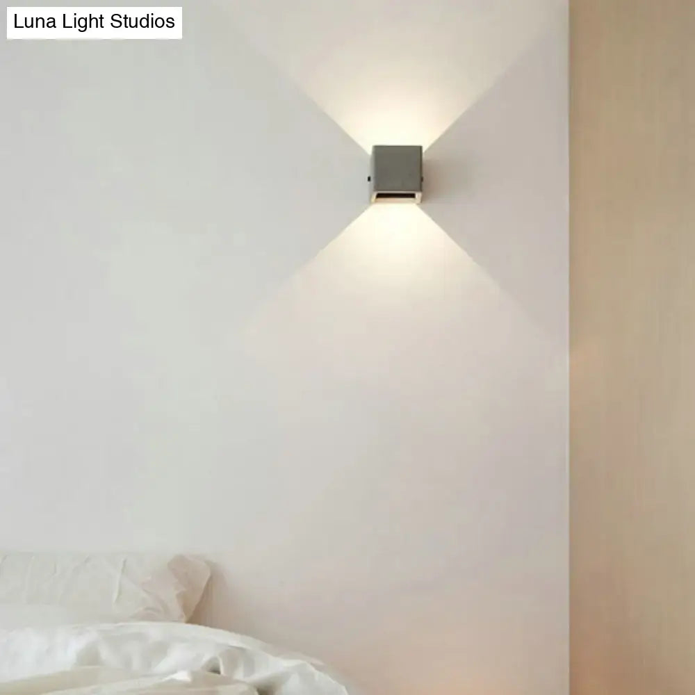 Minimalist black cement led wall lamp with a sleek square metallic body emitting warm focused light for living room